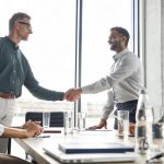 Business professionals shaking hands after a positive customer experience meeting